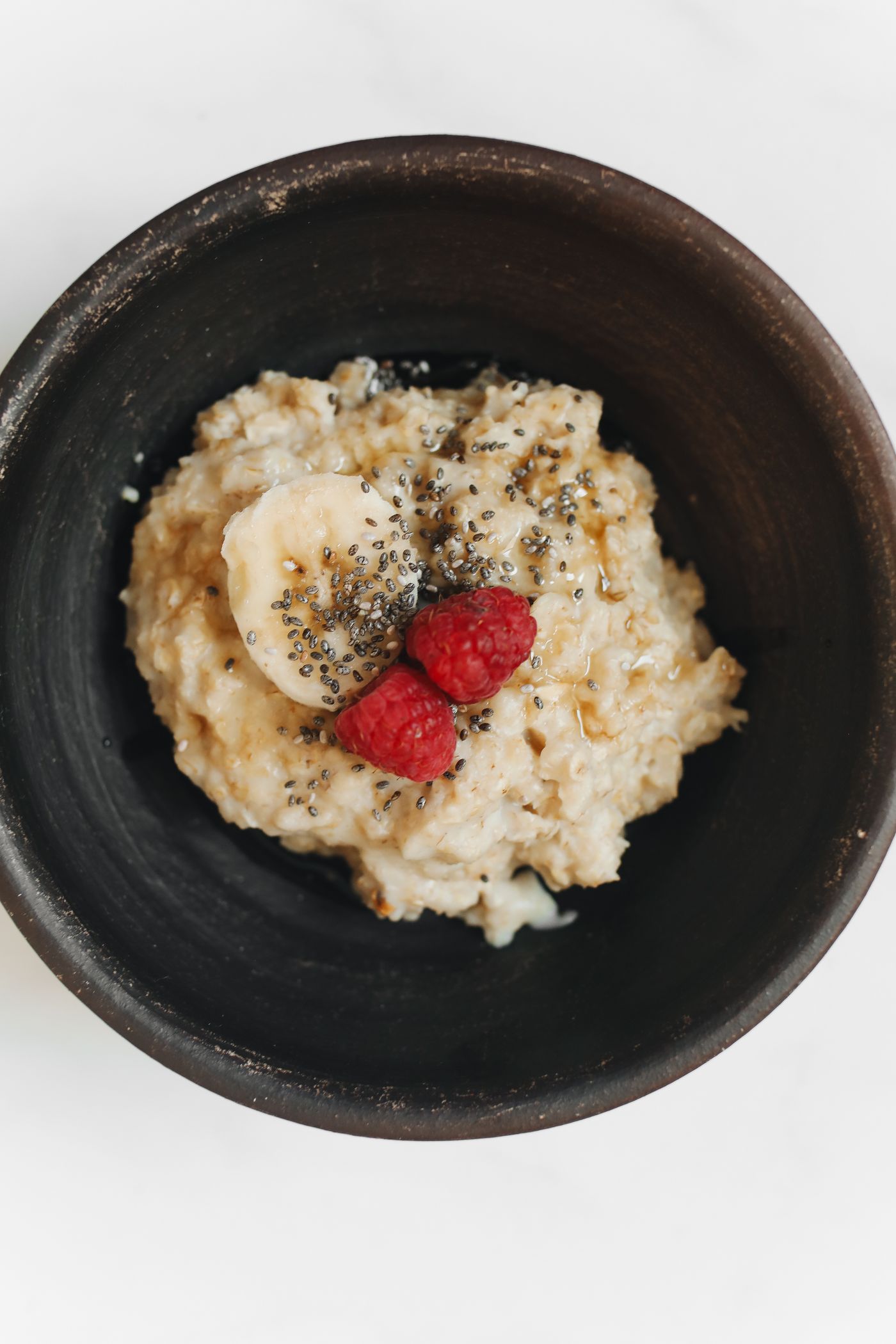 Oatmeal with banana, raspberries and seeds, illustrating balanced nutrition in PCOS care