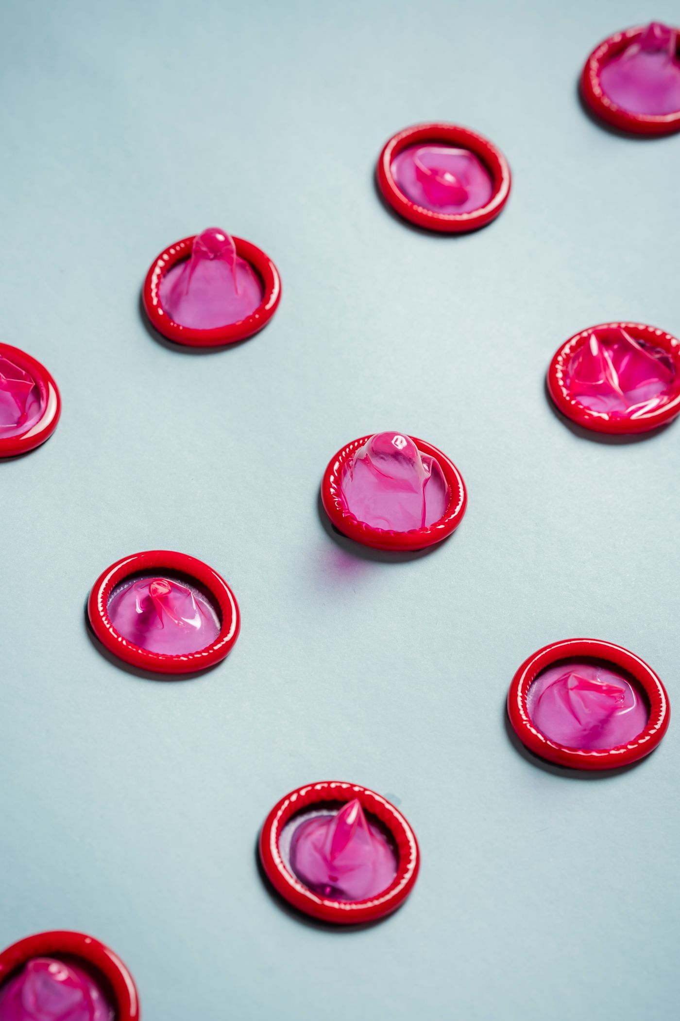 Packaged condoms arranged on a pale background for a contraception guide